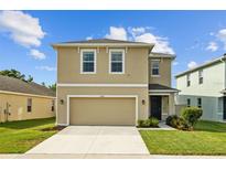 Charming two-story home featuring manicured lawn, neutral stucco, and attached two-car garage at 16121 Soft Fern Trace, Odessa, FL 33556