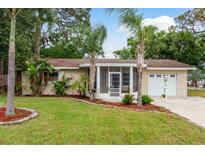 Charming single-story home with well-maintained landscaping and inviting screened entrance at 10623 103Rd St, Largo, FL 33773