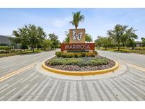 Landscaped Mariposa community entrance sign and roundabout welcome residents and visitors at 10669 Cardera Dr, Riverview, FL 33578