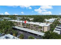 Scenic aerial view of a low rise condo building with mature landscaping and covered parking at 11620 Park Blvd # 306, Seminole, FL 33772