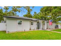 Charming single story home with an American flag, green lawn, landscaping, and inviting entrance at 1641 Jeffords St, Clearwater, FL 33756