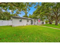 Charming single-story home with manicured lawn, mature trees, and an American flag at 1641 Jeffords St, Clearwater, FL 33756