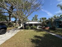 Charming home featuring a well-manicured lawn, awning, and mature landscaping creating lovely curb appeal at 1835 15Th S Ave, St Petersburg, FL 33712