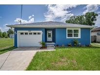 Charming blue home with a well-manicured lawn and attached garage offers curb appeal at 2307 N 47Th St, Tampa, FL 33605