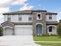 Elegant two-story home featuring a stone facade, a two-car garage, and a well-manicured lawn at 3483 Yellow Leaf Cir, Spring Hill, FL 34609
