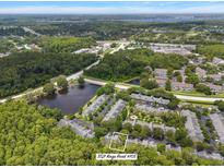 Beautiful aerial view of the neighborhood, pond, and lush landscaping at 3521 Kings Road #105 at 3521 Kings Rd # 105, Palm Harbor, FL 34685