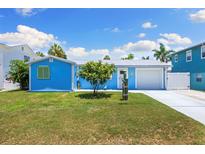 Charming turquoise home with a well-manicured lawn and lovely curb appeal, perfect for coastal living at 4492 Kingston Dr, Hernando Beach, FL 34607
