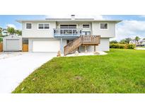 Charming home featuring a well-maintained lawn, garage, and staircase leading to a deck at 4916 Palmetto Point Dr, Palmetto, FL 34221
