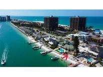 Coastal home with private beach, dock, swimming pool, and beautiful turquoise water views on a clear day at 7777 Bayshore Dr, Treasure Island, FL 33706