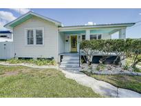 Charming home with a welcoming yellow door and meticulously landscaped front yard at 106 W Minnehaha St, Tampa, FL 33604