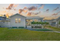 Charming single-story home featuring a well-manicured lawn and a welcoming front porch with meticulously kept shrubs at 106 W Minnehaha St, Tampa, FL 33604