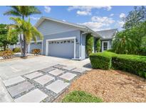 Charming single-story home with a well-manicured lawn, mature landscaping, and a two-car garage at 13636 Lake Point S Dr, Clearwater, FL 33762
