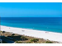 Expansive white sand beach and ocean view provides a tranquil escape with clear blue skies on a sunny day at 1380 Gulf Blvd # 805, Clearwater, FL 33767