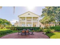 Beautiful outdoor patio featuring a large white home with a balcony and well manicured yard space at 15612 Howell Park Ln, Tampa, FL 33625