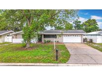 Charming single-story home with a well-maintained lawn, driveway, and attached two-car garage at 1737 Prince Philip St, Clearwater, FL 33755