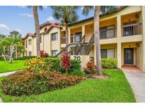 Inviting condo exterior with lush landscaping and palm trees offers a tranquil residential setting at 1801 E Lake Rd # 20 G, Palm Harbor, FL 34685