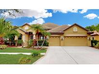Charming single-story home with a tile roof, lush landscaping, and a spacious three-car garage at 20023 Pergola Bend Ln, Tampa, FL 33647