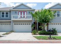 Charming townhome with a two-car garage, lovely landscaping, and a cute second-floor balcony at 2876 Bayshore Trails Dr, Tampa, FL 33611