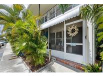 Charming entrance with screen door, awning, and lush tropical landscaping provides a welcoming feel to this beautiful condo at 4154 56Th N St # 720, Kenneth City, FL 33709