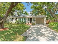 Charming single story home featuring a well maintained lawn, lush trees, and a private carport at 4309 W Empedrado St, Tampa, FL 33629
