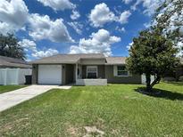 Charming single-story home featuring a well-manicured lawn, attached garage, and a driveway at 6807 Monique Ave, Tampa, FL 33625