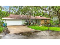 Charming single-story home with a well-manicured lawn and mature trees, creating a welcoming curb appeal at 6901 Arbor Oaks Ct, Bradenton, FL 34209
