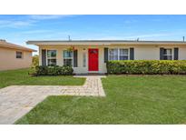 Charming single-story home with a well-manicured lawn and vibrant red door, offering a welcoming curb appeal at 8339 75Th Ave, Seminole, FL 33777