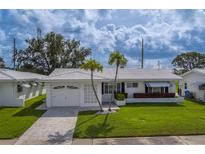 Charming single-story home with white tile roof, well-manicured lawn, and paver driveway, presenting a welcoming curb appeal at 10005 41St N St, Pinellas Park, FL 33782
