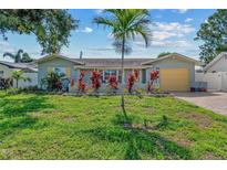 Charming single-story home with vibrant landscaping, mature trees, and a well-manicured green lawn at 10339 111Th St, Largo, FL 33778