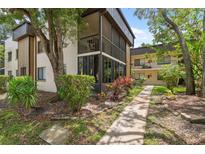 Charming condo featuring a screened lanai, mature trees, and lush landscaping at 11809 Raintree Lake Ln # A, Tampa, FL 33617