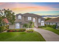 Stunning two-story home with meticulously maintained lawn, mature trees, colorful flower beds, and a winding driveway at 1191 Darlington Oak Ne Dr, St Petersburg, FL 33703