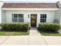 Charming home features a well maintained lawn and beautiful front door with decorative wreath at 13926 Mission Oaks Blvd, Seminole, FL 33776