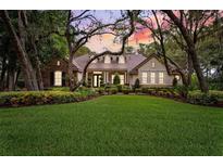 Charming single-story home with well-manicured lawn, lush landscaping, and mature trees at 17802 Mission Oak Dr, Lithia, FL 33547