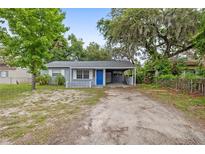 Charming single-story home with a blue door and carport at 2204 E Idlewild Ave, Tampa, FL 33610