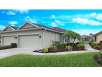 Charming villa featuring an attached garage, well-manicured landscaping, and a quaint front entrance at 2527 Terracina Dr, Venice, FL 34292