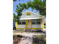 Charming home with a white exterior, bright yellow trim, and a quaint front porch at 3108 56Th S St, Gulfport, FL 33707
