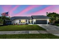 Charming single-story home with a manicured lawn and an American flag at 325 Gladstone Blvd, Englewood, FL 34223