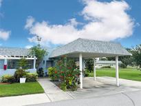 Charming home featuring a covered carport and lovely landscaping with flowering bushes at 3854 Trophy Blvd, New Port Richey, FL 34655