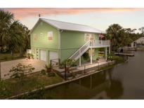 Waterfront home with a metal roof, two car garage, dock and an outdoor staircase to the living area and porch at 5070 Cedarbrook Ln, Hernando Beach, FL 34607