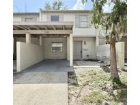 Charming townhouse featuring a covered parking area and a welcoming front entrance at 5229 Tennis Court Circle, Tampa, FL 33617