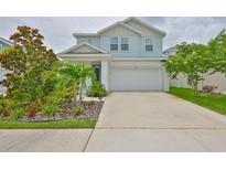 Charming two-story home features a well-manicured lawn and a two-car garage at 5511 Del Coronado Dr, Apollo Beach, FL 33572
