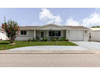Charming single-story home featuring a cozy front porch, landscaped yard, and attached garage at 5840 Liddell Dr, New Port Richey, FL 34652