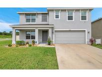 Charming two-story home with a well-maintained lawn and a welcoming front porch at 7641 Sail Clover Ln, Zephyrhills, FL 33540
