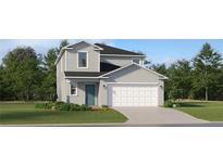 Two-story home featuring a teal front door, lush green lawn, and a two-car garage at 11708 Brae Way, Dade City, FL 33525
