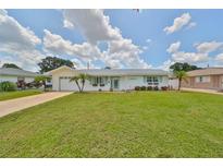 Charming single-story home features a well-manicured lawn, attached garage, and decorative shutters at 1224 W Del Webb Blvd, Sun City Center, FL 33573