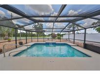 Screened pool with blue tile accents offers a relaxing outdoor oasis with an idyllic golf course view at 1224 W Del Webb Blvd, Sun City Center, FL 33573