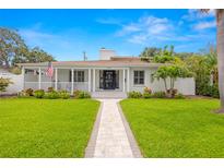 Charming home with manicured lawn and inviting walkway to a covered porch with American flag at 146 26Th Ne Ave, St Petersburg, FL 33704