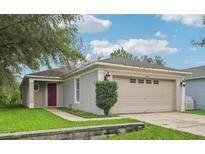 Charming single-story home with a two-car garage, well-maintained lawn, and beautiful landscaping at 1502 Marsh Wood Dr, Seffner, FL 33584