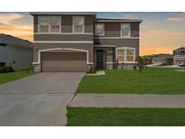 Charming two-story home featuring a well-maintained lawn and a two-car garage at 17005 Avon Dive Ln, Wimauma, FL 33598