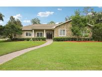 Charming home with a stone facade, manicured lawn, and a brick walkway leading to the front entrance at 1803 143Rd E Ct, Bradenton, FL 34212